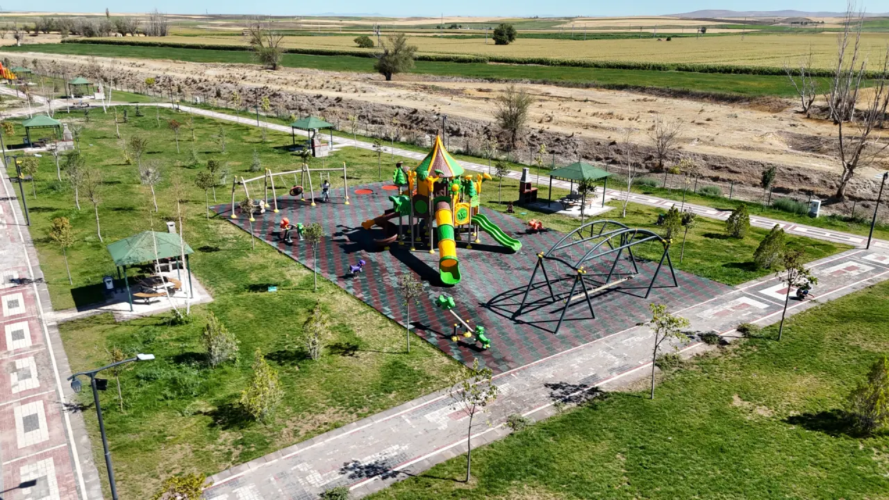 Göletli Park’taki çocuk oyun alanı ve kamelyalar; arka planda ova boyunca uzanan tarlalar